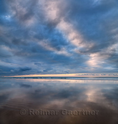 Clouds at sunset and water reflections on wide sandy Inverboyndie Beach at Boyndie Bay Aberdeenshire Scotland UK