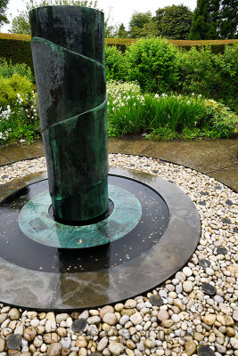 Bronze fountain in the Paradise Garden of the Walled Garden at Cawdor Castle with white flowers in rain Scotland UK