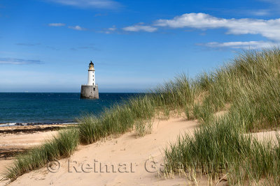 Rattray Head Lighthouse in the North Sea at Buchan Aberdeenshire Scotland with sea grass on sand dunes and sandy beach