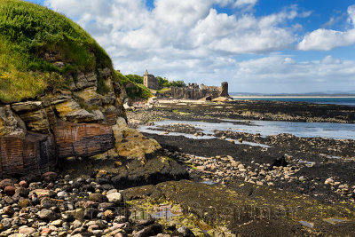 St Andrews Castle ruins with wall to rocky ocean with tide pools and Castle Sands beach in St Andrews Fife Scotland UK