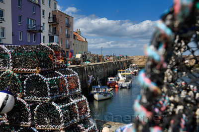 Lobster traps and working fisherman with fishing boats moored at St Andrews Pier Kinness Burn St Andrews Fife Scotland UK