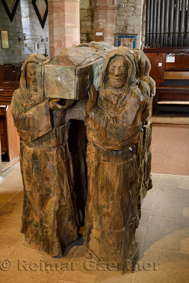 Wood sculpture of monks carrying dead brother in coffin in The Parish Church of Saint Mary the Virgin on Holy Island of Lindisfa