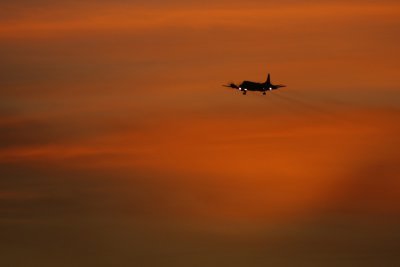 Plane landing in fire-hued dusk sky