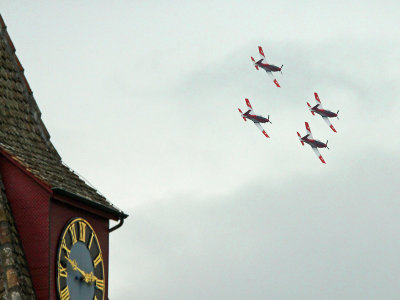 Four PC-7s in formation behind the unique clock tower of the church of my village.