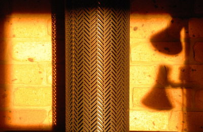 Late light on wood fire chimney and shadows of my lamp beside my chair.
