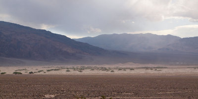 Sand rises above the Mesquite Flats dunes, Death Valley