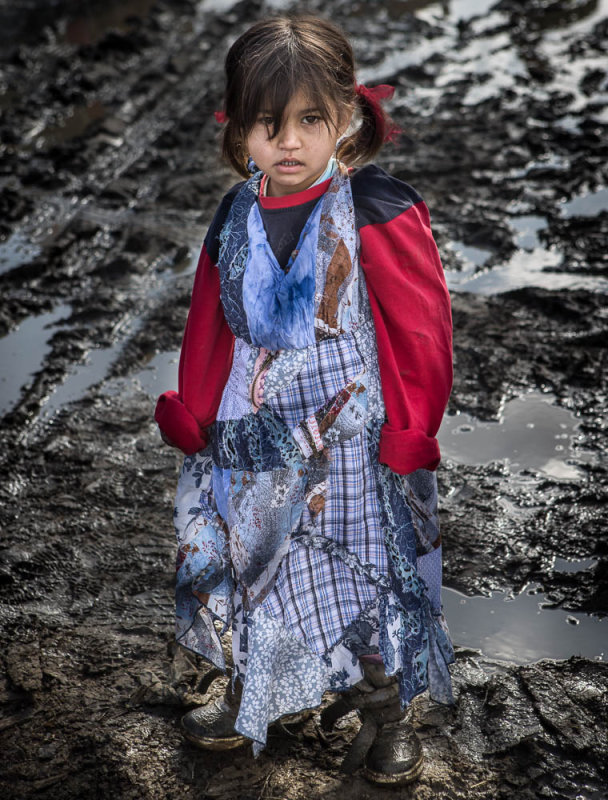 Trying to keep her dress out of the mud.