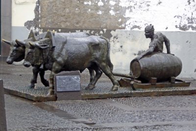 Bronze sculpture of a man and two oxen pulling a sled with a wine barrel, Madeira, Portugal
