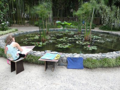 Young girl painting in a lovely botannical garden