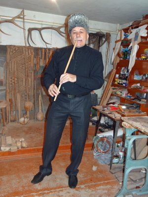 This is an instrument maker in Maykop; he has this flute anchored on a tooth!  Never have I seen this before, but it works.