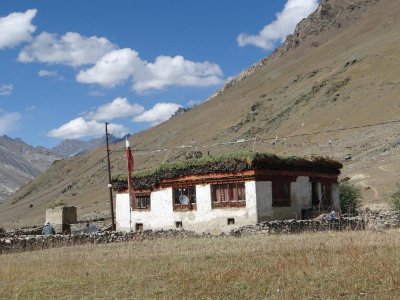 A typical Tibetan style home; note the wood and grass drying on its roof.