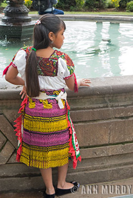 Little girl standing by fountain
