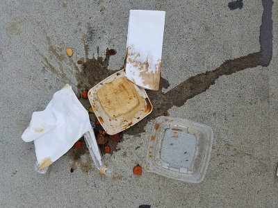 food, paper and plastic on concrete