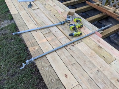 Pipe clamp holding warped deck board in place