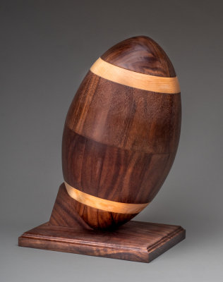 Urn in the shape of a bootball from Walnut and Maple.