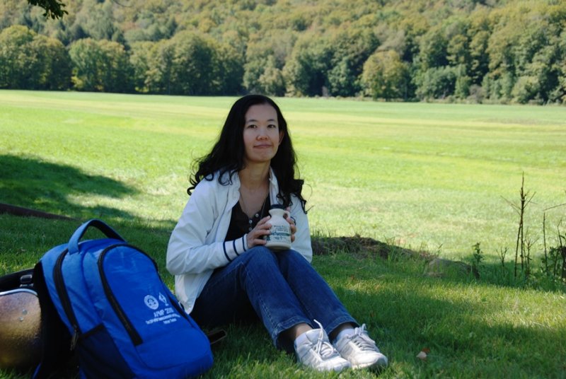 Su sitting in a meadow with ......