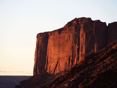 The just risen sun lights up the cliff face at Monument Valley