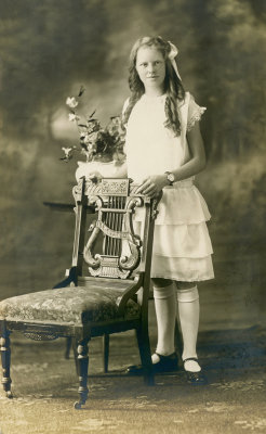 Girl standing by a chair  