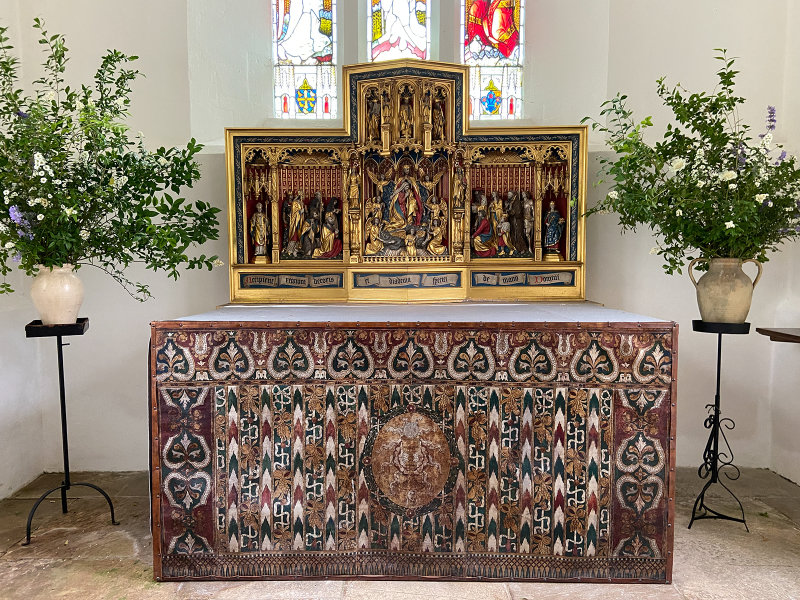 All Saints Church - The chancel has a simple rail and altar. The painted reredos is some of the finest work by FC Eden.