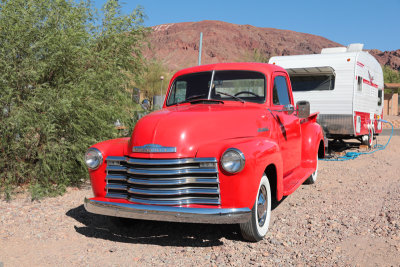 Red Chevy pickup truck and trailer