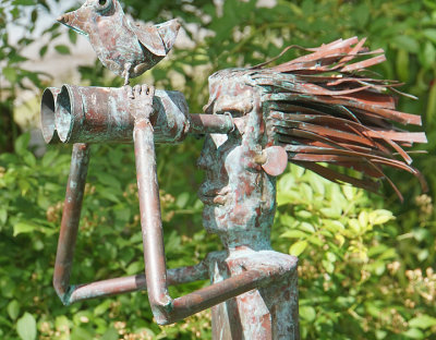 Man & bird with binoculars metal sculpture.