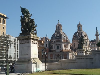 View past bronze sculptures of Complex to two domes of Catholic churches and on the right the Column of Trajan