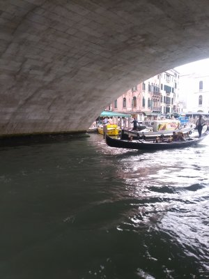 Passing under the fat arch of the bridge. Gondolier's voice echoing as he enters beside us