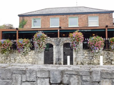 The Curragower with it's lovely flower baskets on an old stone wall