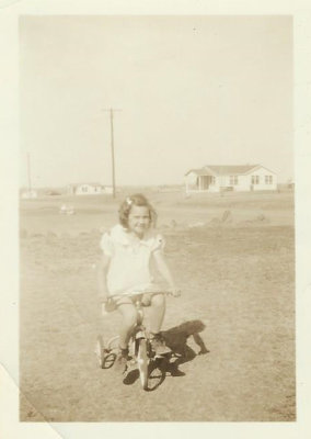 Jackie as a child on a tricycle