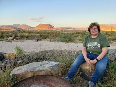 Mary relaxing with the eastern landscape in the sunset light behind her, at our B&B outside Terlingua, TX