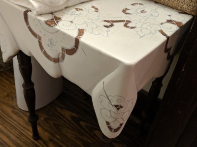 There was a small table next to the bathroom sink that Mary noticed had a carved and painted top.