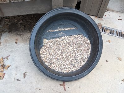 I bought a sack of pea gravel to use to cover the top of the fountain, washed the gravel several times, then propped the container in the sun to help it dry.