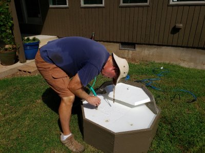 Proof of concept #1: after attaching the pump to a tube that I had inserted through holes in the shell of the fountain, I placed everything over the plastic tub reservoir and filled the tub underneath through one of the drainage holes in the deck.