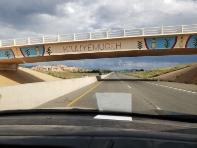Highway contractors chose artists Frederico Vigil, Anthony Dorame and George Rivera to design the bridge artwork. Rivera, lieutenant governor of Pojoaque pueblo, came up with the designs for the Cuyamungue and Pojoaque overpasses. The words K'uuyemugeh and P'osuwageh the Tewa names for the two communities are written on the center of the overpasses.