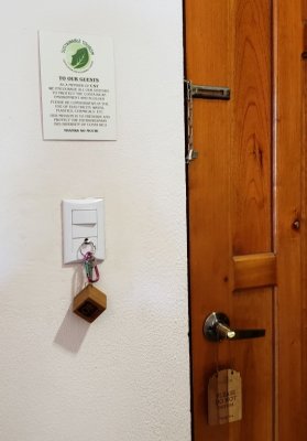 We put the room key on the hook on the light switch to turn on the light.