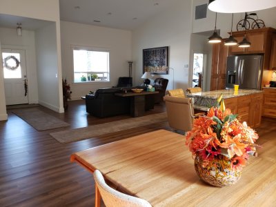 Looking from the dining room toward the front door, den and kitchen bar