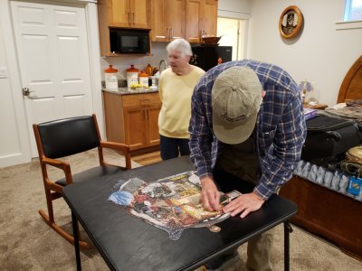 Steve helped Jackie finish the puzzle she'd been working on and she let him put in the last piece.