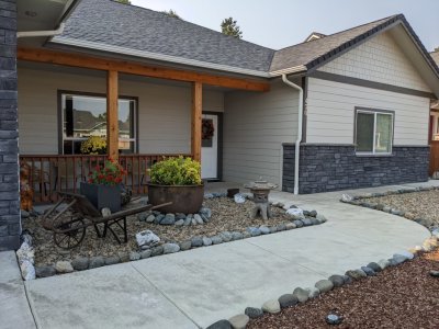 Close-up of the sidewalk, front door and more of Pepper's handiwork--the wheelbarrow and flowers.
They hauled that big iron pot and all the bigger border rocks from Powers also.