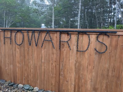 Pepper's welded chain name hanging on the back fence