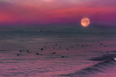 setting full moon with surfers