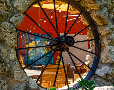 Caf terrace through a wagon wheel opening in the stone wall. (6/14)