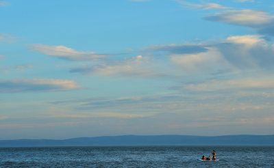 Paddle boarding pair. Cliffs of north Somerset on the horizon.