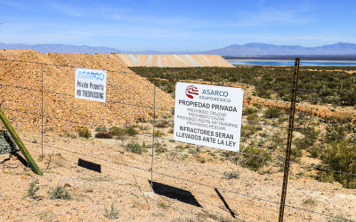 Tailings and tailings pond beyond the property fence at the ASARCO Copper Mine