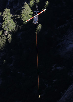Search and Rescue helicopter long line rescue process as seen from Taft Point in Yosemite National Park