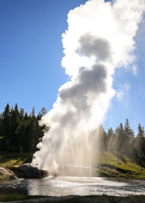 Steam from the Riverside Geyser eclipses the sun in the Upper Geyser Basin in Yellowstone National Park