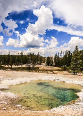 Thunder clouds building over Crater Spring in the Norris Geyser Basin in Yellowstone National Park