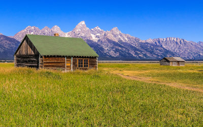 John Moulton Homestead Bunkhouse with the Grand Tetons in the background in Grand Teton National Park