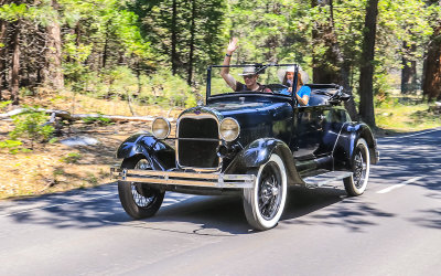 Couple driving an old Ford through Yosemite National Park