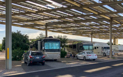 RV parked under a large solar panel awning at a KOA RV Park during a blistering hot summer in Tucson