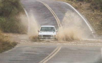 A small truck throws up rainwater crossing a flooded wash in Tucson Mountain Park
